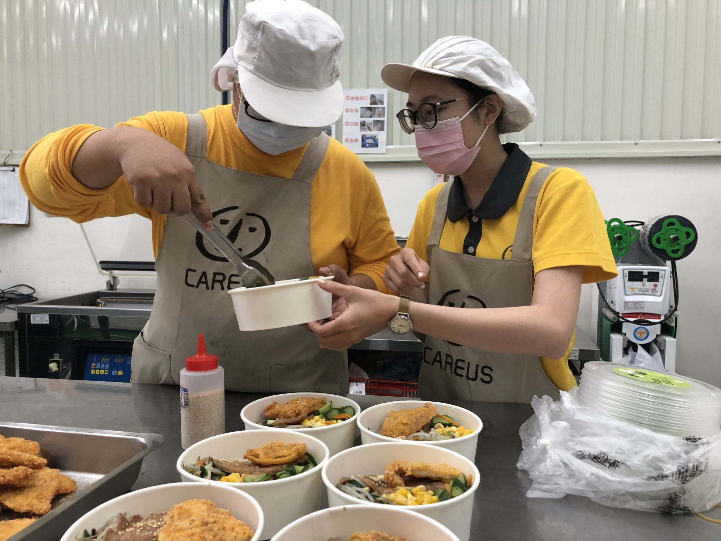 教保員教導憨兒如何盛裝便當